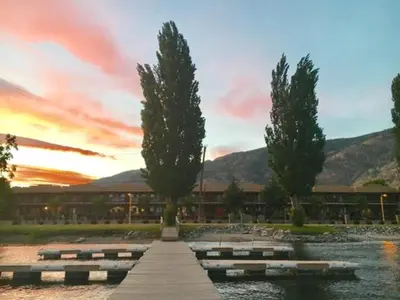 a building with trees and water in front of it at Casa Del Mila Oro in Osoyoos