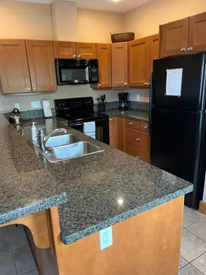 a kitchen with a sink and a black refrigerator at Casa Del Mila Oro in Osoyoos