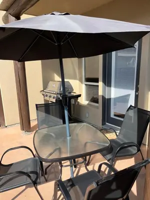 a table and chairs with an umbrella on a patio at Casa Del Mila Oro in Osoyoos