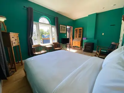 a bedroom with a white bed and green walls at The Inn at Tough City in Tofino