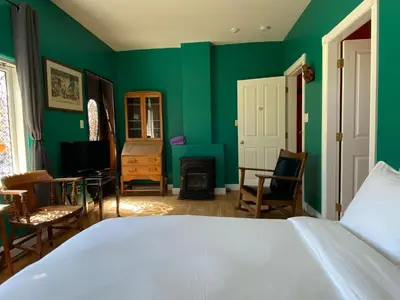 a bedroom with green walls and a bed at The Inn at Tough City in Tofino