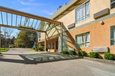 a building with a glass entryway in front of it at Motel 6 Surrey, Bc in Surrey