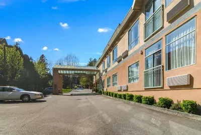 a building with a bridge next to a street at Motel 6 Surrey, Bc in Surrey