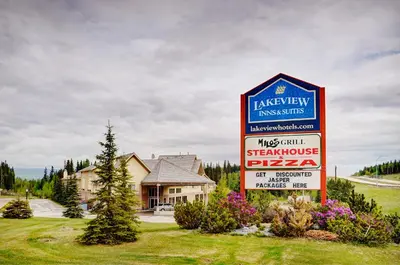 a sign in a yard in front of a house at Lakeview Inns & Suites - Hinton in Hinton
