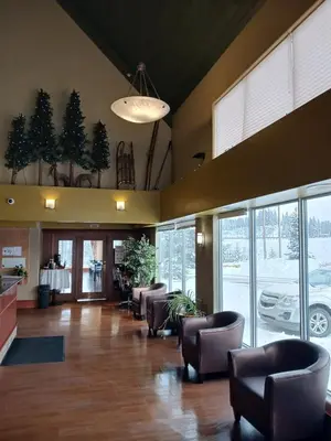 a lobby with chairs and a waiting room with a car dealership at Lakeview Inns & Suites - Hinton in Hinton