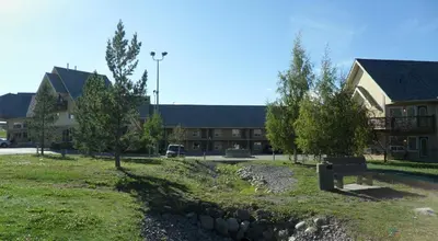 a park with a bench in front of a building at Lakeview Inns & Suites - Hinton in Hinton
