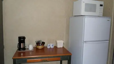 a white refrigerator with a microwave on top of it at Lakeview Inns & Suites - Hinton in Hinton