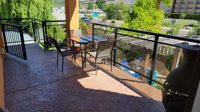a balcony with a table and chairs on it at Sahara Courtyard Inn & Suites Osoyoos in Osoyoos