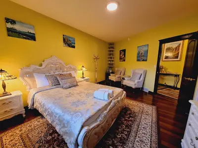 a bedroom with a large bed and yellow walls at Villa Bellissimo FranTalia - Résidence & Galleriséum in Kelowna