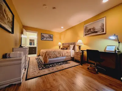 a bedroom with yellow walls and a bed and a desk at Villa Bellissimo FranTalia - Résidence & Galleriséum in Kelowna