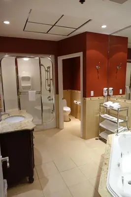 a bathroom with two sinks and a shower and a toilet at Chateau Louis Hotel & Conference Centre in Edmonton