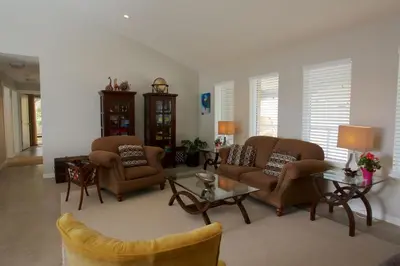 a living room with two chairs and a table at Halfmoon Haven Beach Cottage or Oceanview Suite in Halfmoon Bay