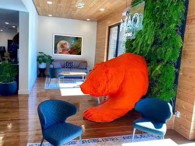 a large orange bear statue in a lobby at The Maq Hotel in Tofino