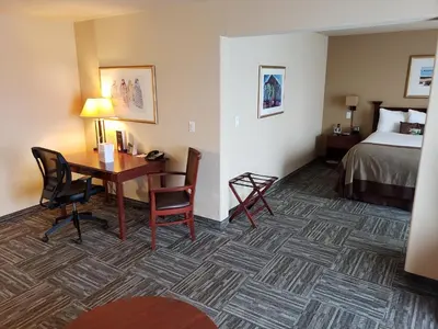 a hotel room with a desk and a bed at Wingate by Wyndham - Edmonton West in Edmonton