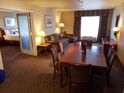 a hotel room with a dining table and a living room at Wingate by Wyndham - Edmonton West in Edmonton
