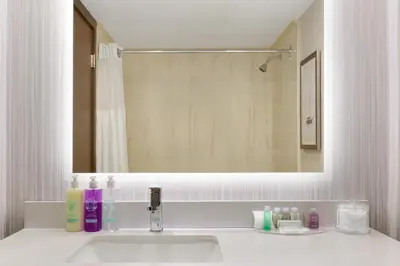 a bathroom with a sink and a large mirror at Coast Discovery Inn in Campbell River