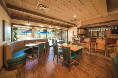 a restaurant with tables and chairs and a bar at Coast Discovery Inn in Campbell River