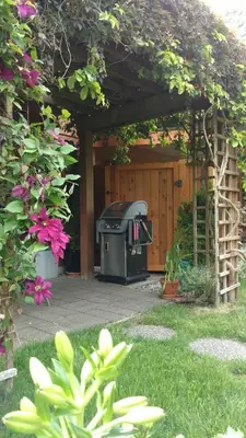 a pergola with a grill in a yard at Nestledown B&B in Halfmoon Bay