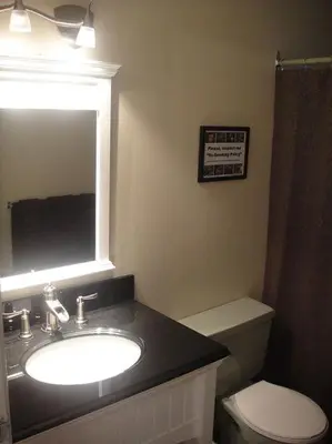 a bathroom with a sink and a toilet and a mirror at Edgewater Motel in Oyster Bay