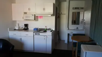 a small kitchen with white cabinets and a sink at Cactus Tree Inn in Oliver