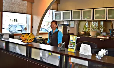 a man standing behind a counter in a restaurant at Centre Suite Inns Motel in Bonnyville