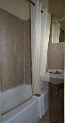 a bathroom with a bath tub and a sink at Centre Suite Inns Motel in Bonnyville