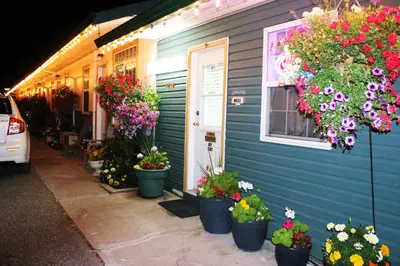 a house with potted flowers on the side of it at Boundary Motel in Osoyoos