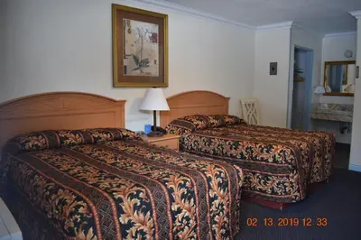 a hotel room with two beds and a picture on the wall at Evening Star Motel in Greenwood