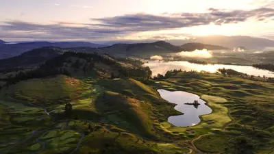 an aerial view of a golf course with a lake at Predator Ridge Resort in Vernon