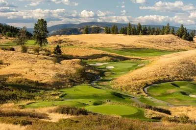 an aerial view of a golf course with a hill at Predator Ridge Resort in Vernon