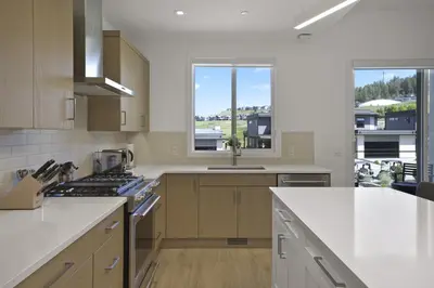 a kitchen with white countertops and a large window at Predator Ridge Resort in Vernon