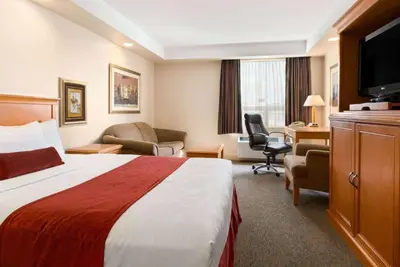 a hotel room with a bed and a desk at Travelodge by Wyndham Spruce Grove in Spruce Grove
