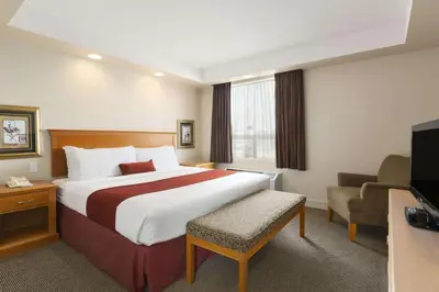 a hotel room with a bed and a television at Travelodge by Wyndham Spruce Grove in Spruce Grove