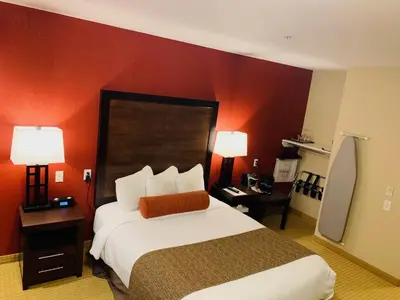 a hotel room with a large bed and red walls at The Kanata Inns Invermere in Invermere