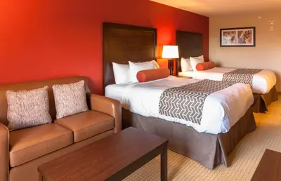 a hotel room with two beds and a couch at The Kanata Inns Invermere in Invermere