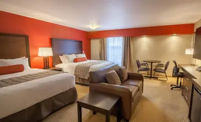 a hotel room with two beds and a desk at The Kanata Inns Invermere in Invermere
