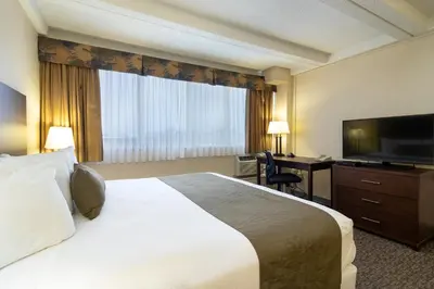 a hotel room with a bed and a flat screen tv at BCM Inns Fort McMurray - Downtown in Fort McMurray