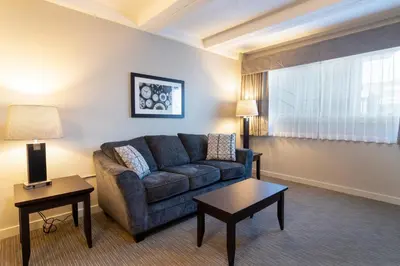 a living room with a couch and a table at BCM Inns Fort McMurray - Downtown in Fort McMurray