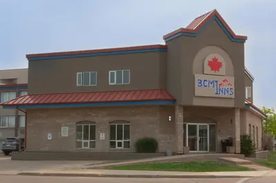 a front view of a building with a sign on it at BCM Inns Fort McMurray - Downtown in Fort McMurray