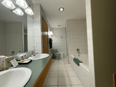 a bathroom with two sinks and a tub and a toilet at Best Maple Inn - Drayton Valley in Drayton Valley