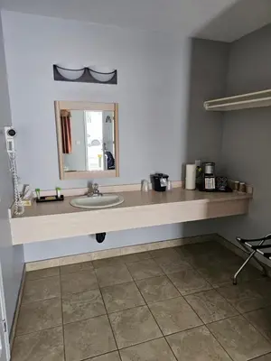 a bathroom counter with a sink and a mirror at BCMInns - Coleman in Coleman