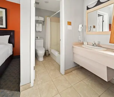 a bathroom with a bed and a sink and a toilet at BCMInns - Coleman in Coleman