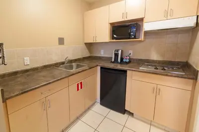a small kitchen with a sink and a microwave at BCMInns - Fort McMurray - Rusty's in Fort McMurray