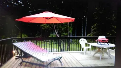 a table and two chairs and an umbrella on a deck at Gabriola Central B&B in Gabriola