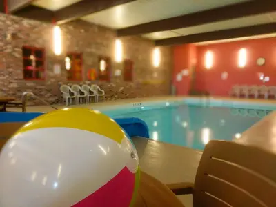 a beach ball sitting on a table next to a swimming pool at BCMInns - Lloydminster in Lloydminster