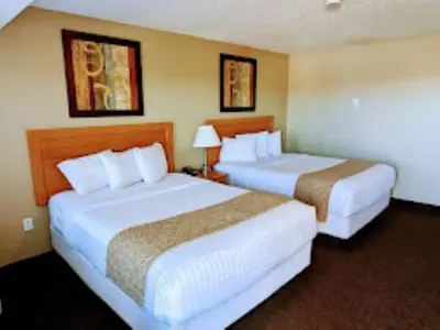 a hotel room with two beds and two lamps at BCMInns - Lloydminster in Lloydminster