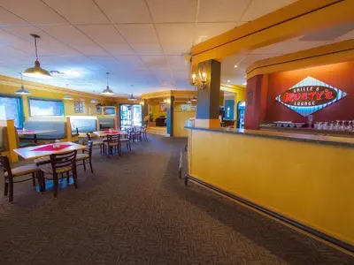 a fast food restaurant with tables and a bar at BCMInns - Lloydminster in Lloydminster