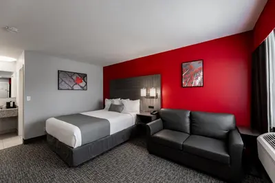 a hotel room with a bed and a chair at The Kanata by BCMInns - Hinton in Hinton
