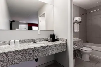 a bathroom with a sink and a toilet and a mirror at The Kanata by BCMInns - Hinton in Hinton