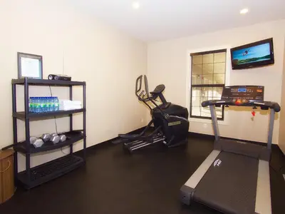 a room with a gym with a treadmill and a exercise bike at BCMInns - Lac La Biche in Lac La Biche